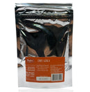 A silver metallic stand-up pouch of Budro Dry Ajika, featuring a prominent orange label with product details, set against a plain white background with a soft reflection below.
